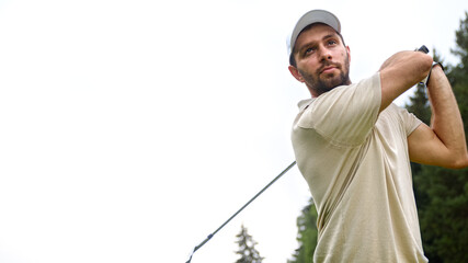 Young man in a cap playing golf close-up