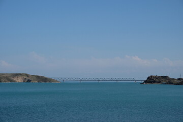 Fototapeta premium Railway blridge over lake with cloudy blue sky background.