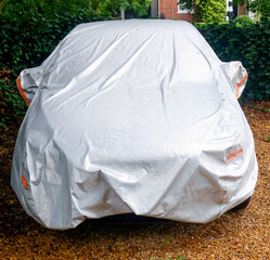 Automobile under protective fabric car cover.