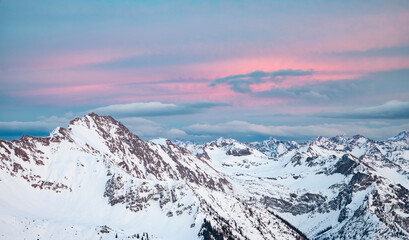Colorful clouds over snow-covered mountain range at sunset in winter. Allgau Alps, Bavaria, Germany