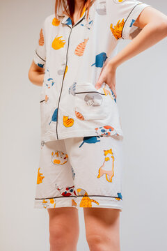 Beautiful booty of a young woman in fashionable white pajamas with colorful designs