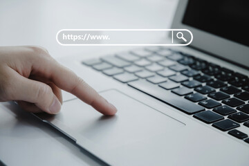 people hand touching touchpad on laptop computer with www search bar graphic on desk at home...