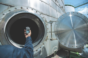 Worker hand holding gas detector inspection safety gas testing at front manhole stainless tank