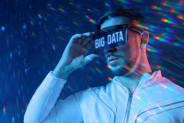 Man with futuristic tablet in hand. Guy using VR glasses. Big Data, augmented reality, future technology concept. Blue neon light. Futuristic holographic interface to display data.