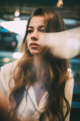 Filter view of contemplative hipster girl with curly brunette hair thoughtful looking away and...