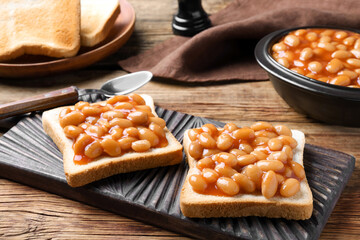 Toasts with delicious canned beans on wooden table