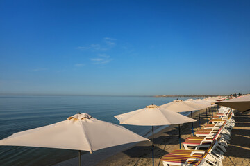 Fototapeta na wymiar Many beach umbrellas and sunbeds at resort