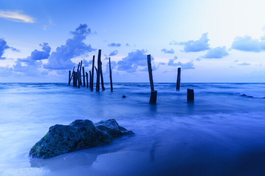 Old wooden bridge abandoned pier stumps at Thungsang bay in Chomphon province Thailand, Tropical beach seaside, White Balance effect