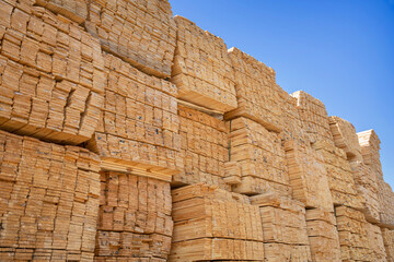 Obraz premium Wooden boards, lumber, industrial wood, timber. Pine wood timber stacked at the port site 