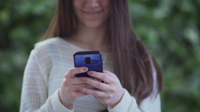 Woman holding mobile phone in her hands and texting message, sufring social network