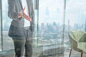 business caucasian man standing and show hand with blurred city background