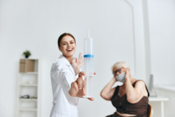 Fototapeta premium Nurse giving injection to an elderly woman vaccination hospital
