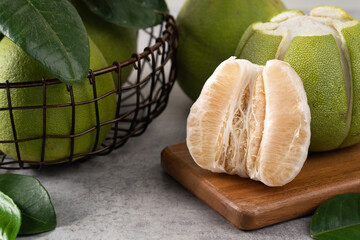 Fresh pomelo fruit on gray cement background.
