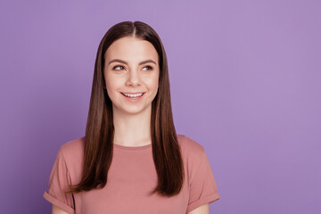 Fototapeta premium Portrait of yong woman smile look empty space over violet background