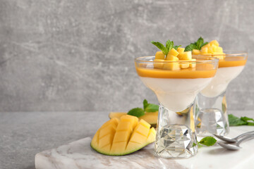 Delicious panna cotta with mango coulis served on light grey table. Space for text