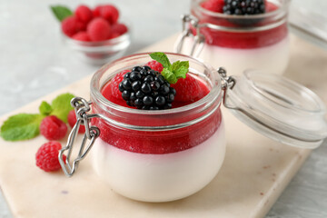 Delicious panna cotta with fruit coulis and fresh berries on light table