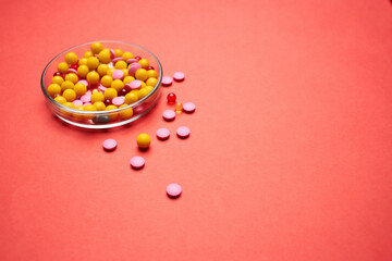 multicolored pills health treatment red background