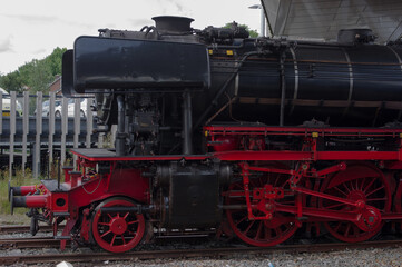 Front of a old historic steam black locomotive with red wheels at station Dieren in the Netherlands