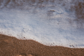 foam and sand on the shore