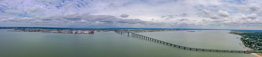 Fototapeta na wymiar Große Panorama Luftaufnahme, Drohnenaufnahme der Saint-Nazaire-Brücke an der Loire Mündung in den atlantischen Ozean, Mindin, Département Loire-Atlantique, Frankreich