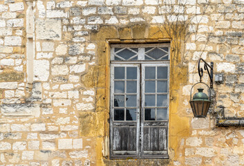 Fenster mit alter Strassenlaterne an einem alten Haus in der historischen Altstadt von Monpazier, Département Dordogne, Nouvelle-Aquitaine, Frankreich