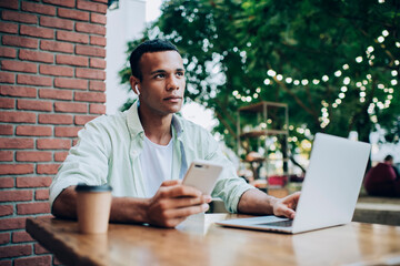 African American guy studying on laptop with mobile