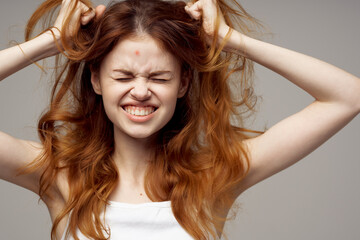 red-haired woman cosmetology skin care puberty light background