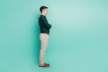 Fototapeta na wymiar Profile portrait of self-assured positive guy folded arms look empty space toothy smile on teal background