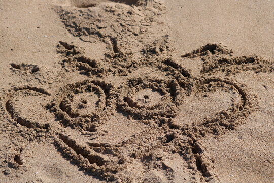 children drawing  on sand