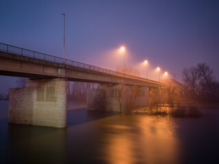 Fototapeta na wymiar Concrete bridge over the Sava River in Bosanski Brod during the winter at dusk