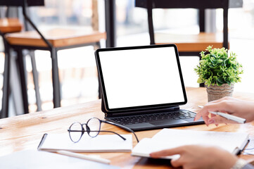 Fototapeta premium Cropped shot of woman hand working on tablet with keyboard at office desk.