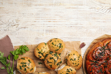 Traditional Ukrainian bread (Pampushky) with garlic on white wooden table, flat lay. Space for text