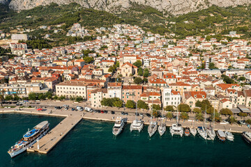 Fototapeta na wymiar Aerial view of Makarska town below Biokovo mountain, the Adriatic Sea, Croatia