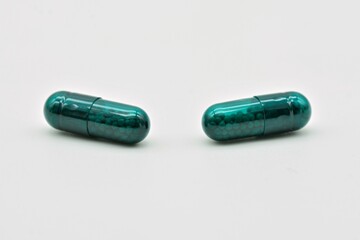 Forma farmacéutica de cápsulas verdes, aislado sobre fondo blanco