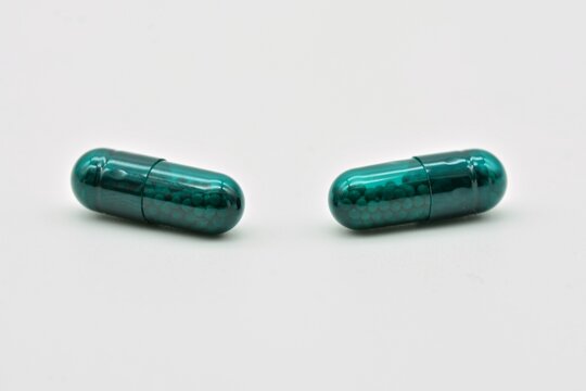 Forma farmac&eacute;utica de c&aacute;psulas verdes, aislado sobre fondo blanco