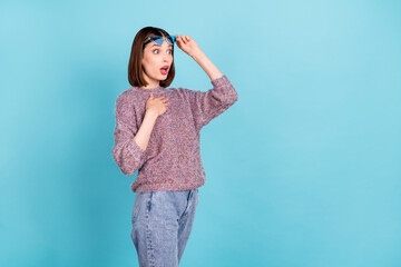 Photo of surprised adorable lady look empty space omg face wear sunglass knitted sweater isolated blue color background