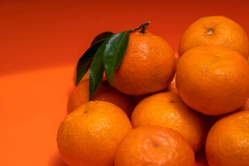 Fresh Mandarin orange fruits, tangerine, yellow-orange clementine with green leaves