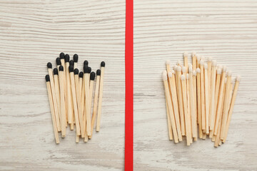 Flat lay composition with different matches on white wooden background. Racism concept