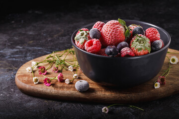 Black bowl of frozen red fruits
