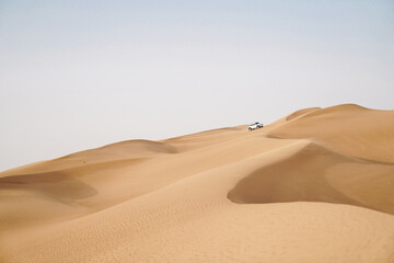 Offroad SUV vehicle bashing through landscape of desert sand dunes adventure 
