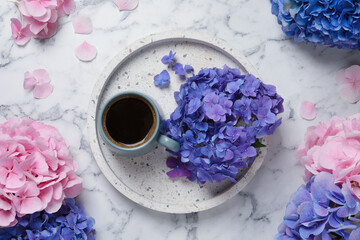 Obraz na płótnie Canvas Beautiful hortensia flowers and coffee on white marble table, flat lay