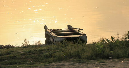 wooden boat on the shore at sunset