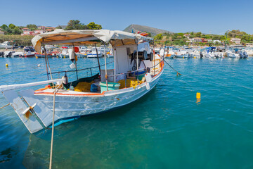 Fototapeta na wymiar Small wooden fishing boat moored in Greek port