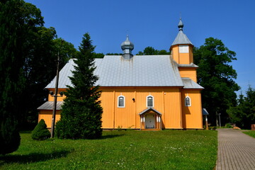 A close up on an old abandoned wooden church with a thatch angled roof, glass windows, and a tall...