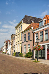 Fototapeta na wymiar Zwolle, The Netherlands, August 4, 2021: row of historic houses with colorful brick and plaster facades along downtwon Thorbecke canal