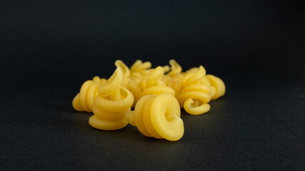 spiral shaped pasta on black background