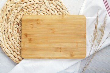 Wooden cutting board mockup, top view composition with wicker mat, kitchen towel and dried plants,...