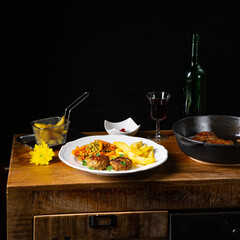 Homemade meatballs with french fries and vegetables
