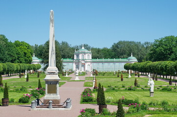 Moscow, Russia - June 17, 2021: Obelisk in honor of Catherine II and a large stone greenhouse in the Kuskovo Estate 