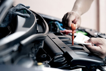 Hand a car mechanic hold the white cloth stained with engine oil checking oil level in a mechanical...